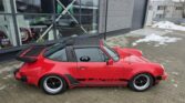 Profil lateral Porsche 911 Targa din 1978 cu plafon detașabil și roll-bar negru distinctiv, parcat pe asfalt.